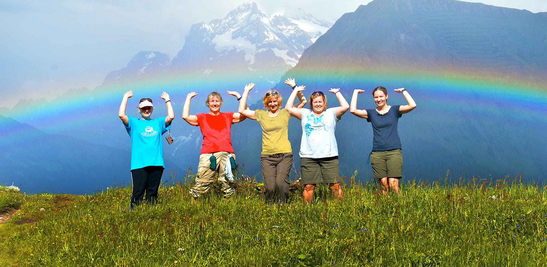 Women holding up a rainbow in the Swiss Alps - Canyon Calling Adventure Tours
