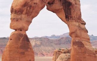 Women hiking beneath Utah's Delicate Arch