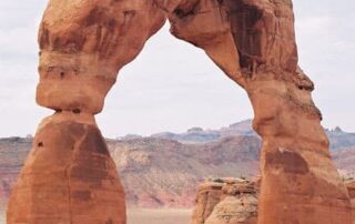 Women hiking beneath Utah's Delicate Arch
