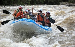 Women river rafting together in small groups on a river in Costa Rica