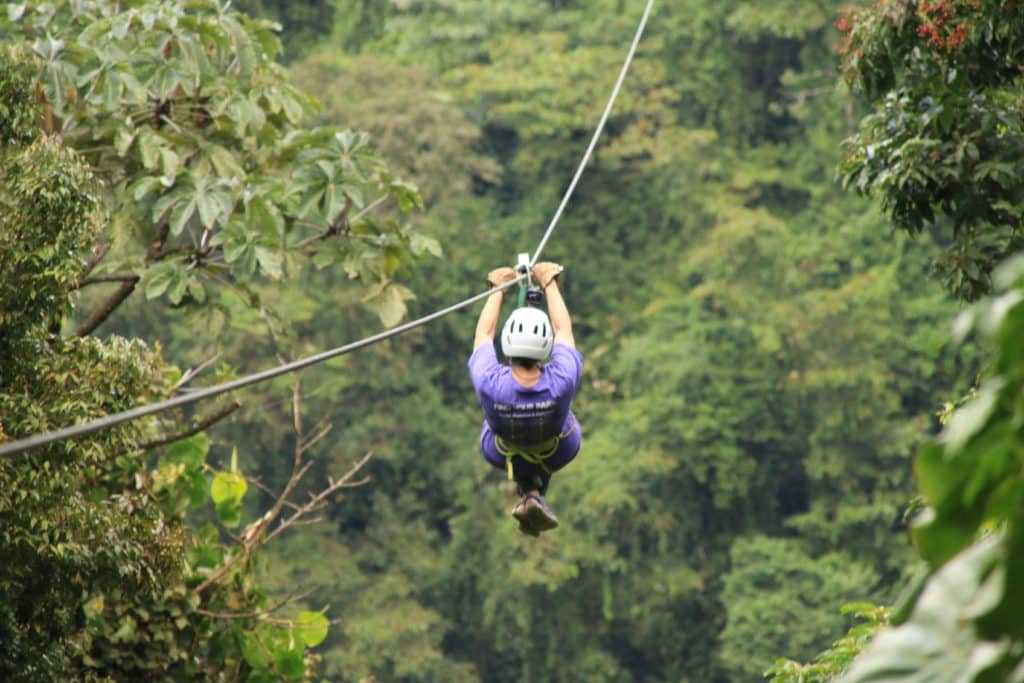 Woman ziplining over the Costa Rica jungle - Active trips with Canyon Calling