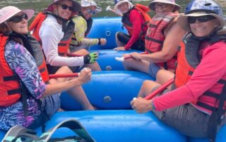 Smiling women rafting on Idaho's rivers with Canyon Calling Adventure Tours