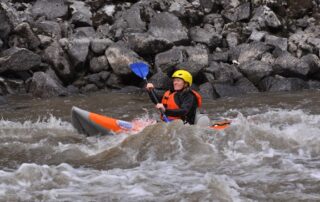 Woman kayaking along a river in Idaho - Canyon Calling Adventure Tours