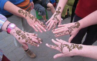 Get lovely henna tattoos with fellow women travelers on vacation to Morocco - Canyon Calling Getaways