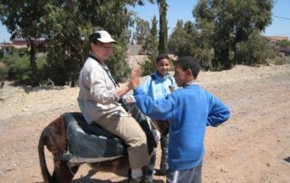 Woman riding a donkey and connecting with locals in Morocco