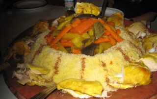 Try local cuisine in Bountiful Moroccan dish atop floral tablecloth in Jemaa el Fna Square, Morocco with fellow women travelers