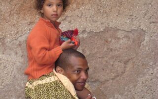 Child riding on the shoulders of a man in Morocco