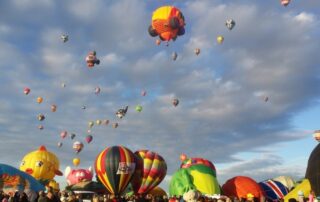 Several bright-colored hot-air balloons flying over the Albuquerque International Balloon Fiesta, NM