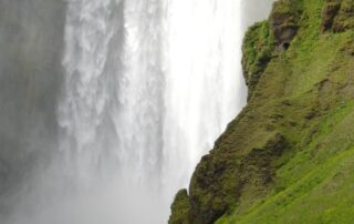 Walk behind the lush Skogarfoss waterfall with your tribe