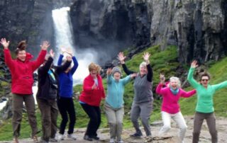 Small group of women celebrating in front of one of Iceland's waterfalls