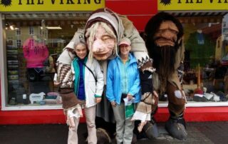 Women posing with troll Viking statues outside a store in Reykjavik, Iceland