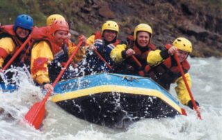 Women having the time of their lives river rafting on a trip to Iceland with Canyon Calling