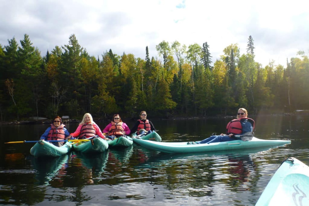 Women’s Travel Adventure Tour of Minnesota during the Fall. Photo: Autumn kayaking on a calm lake