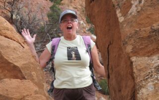 Woman exploring red rock formations with Canyon Calling trips to NM