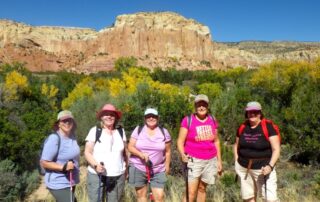 Women trekking together in small groups to the red buttes of New Mexico