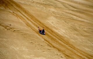 Go sand tobogganing with fellow women adventurers on trip to New Zealand with Canyon Calling Adventure Tours