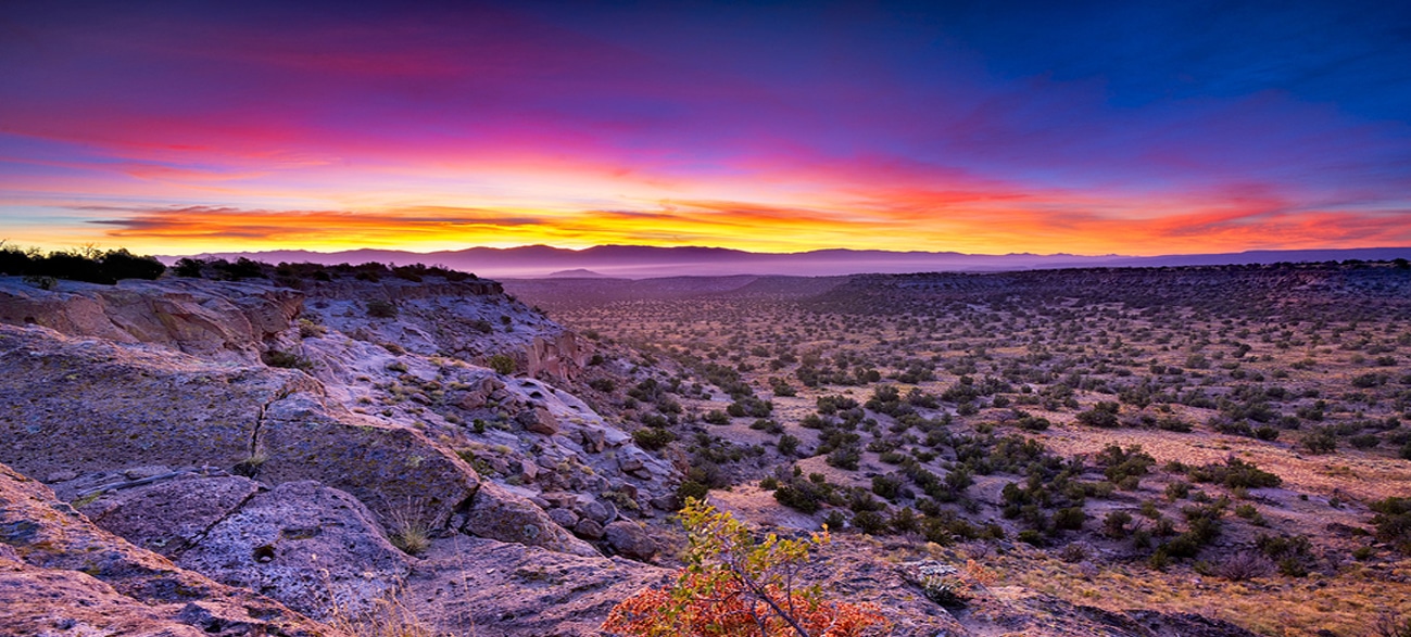 Beautiful desert terrain beneath vibrant sunset - New Mexico getaways for women