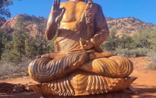 Buddha statue amidst red rocks - Women Travel Adventure Tours to AZ