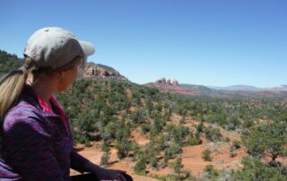 Woman spying Cathedral Rock in the distance in Sedona, AZ