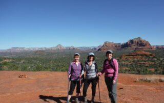 Women hiking in small groups along one of Sedona's red rock plateaus