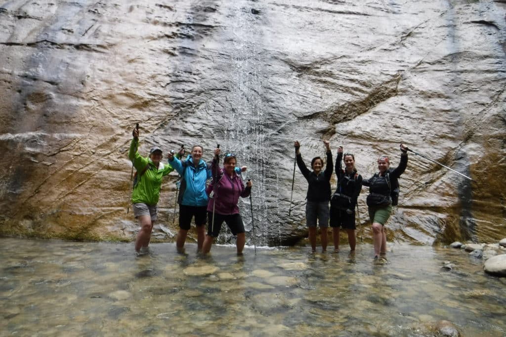 Women having a great time hiking through shallow water in one of Utah's beautiful canyons